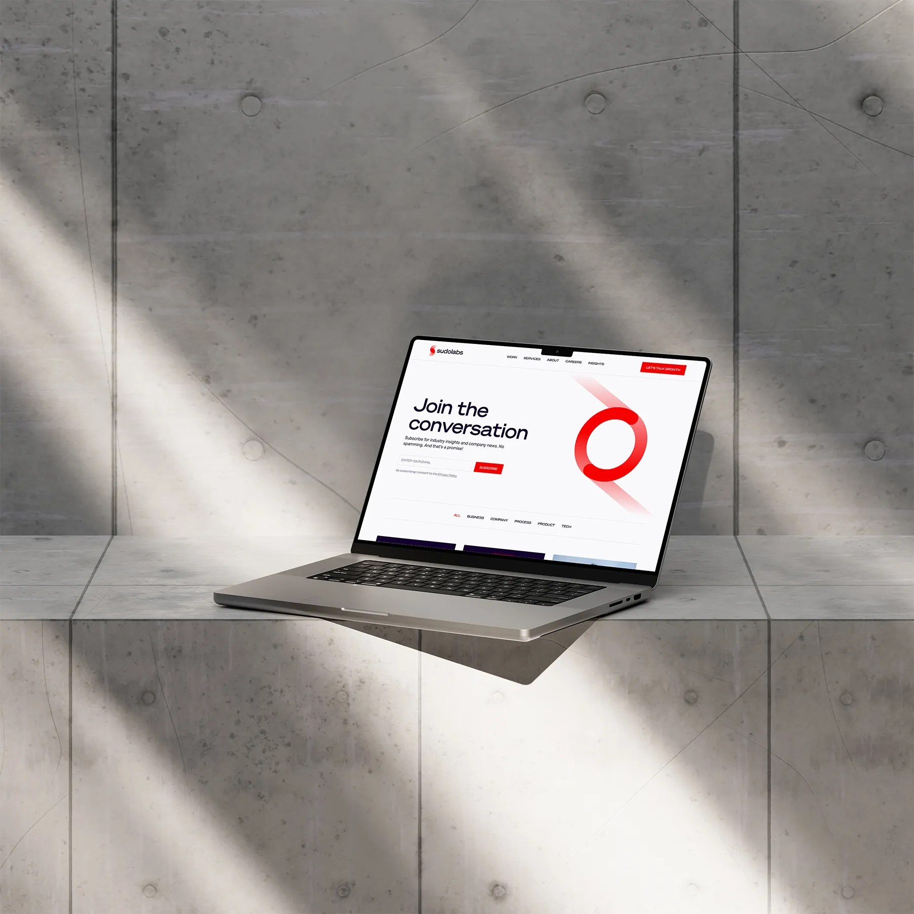 Laptop placed on a concrete/marble surface showcasing a blog section of Sudolabs project.
